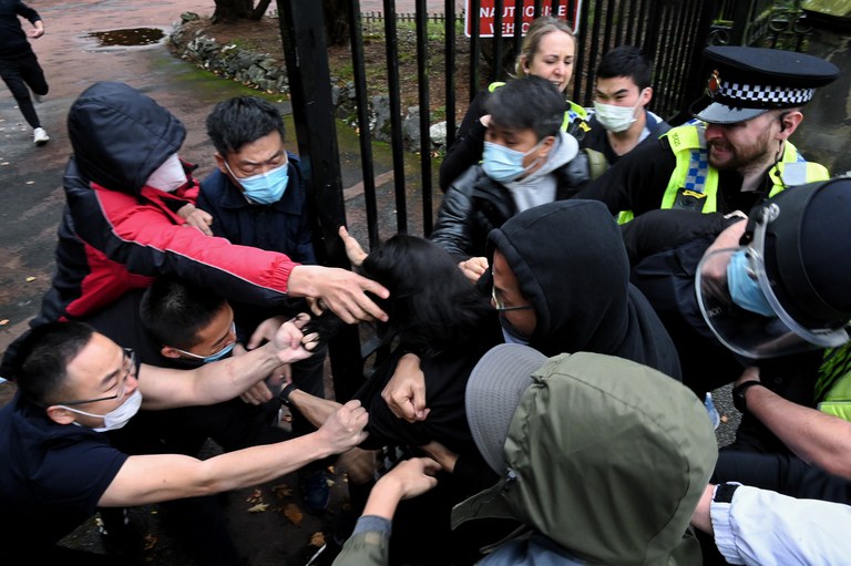 Bob Chan scuffles with people trying to drag him through the gates of the Chinese consulate grounds in Manchester, England, Oct. 16, 2022. Credit: Matthew Leung/The Chaser News via AP
