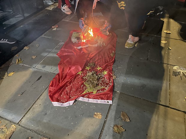 Protesters at the Chinese Embassy in London throw maggots and debris onto a Chinese flag and then set it on fire, Oct. 1, 2022. Credit: RFA