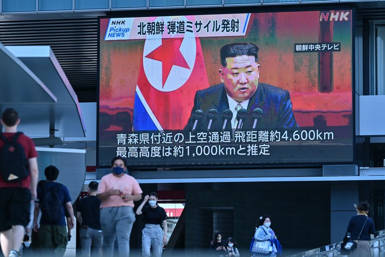 Pedestrians walk under a large video screen showing images of North Korea's leader Kim Jong Un during a news update in Tokyo on Oct. 4, 2022, after North Korea launched a missile prompting an evacuation alert when it flew over northeastern Japan. Credit: AFP