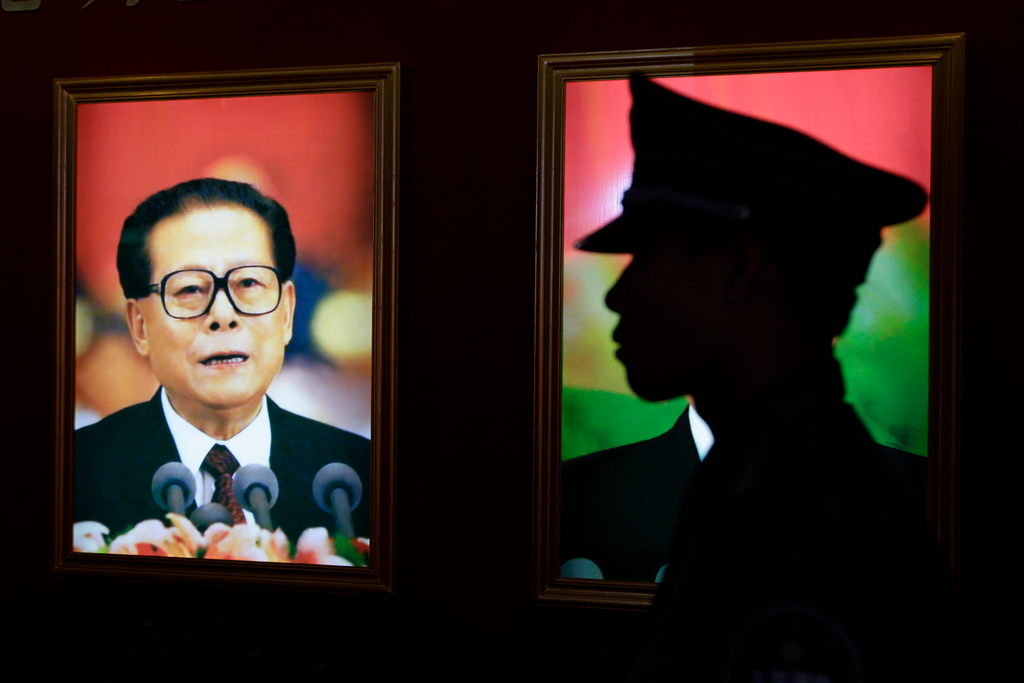 A security guard stands next to a portrait of China's former President Jiang Zemin at an exhibition to celebrate the 90th anniversary of the founding of the Communist Party of China (CPC) in Beijing July 7, 2011. Credit: Reuters
