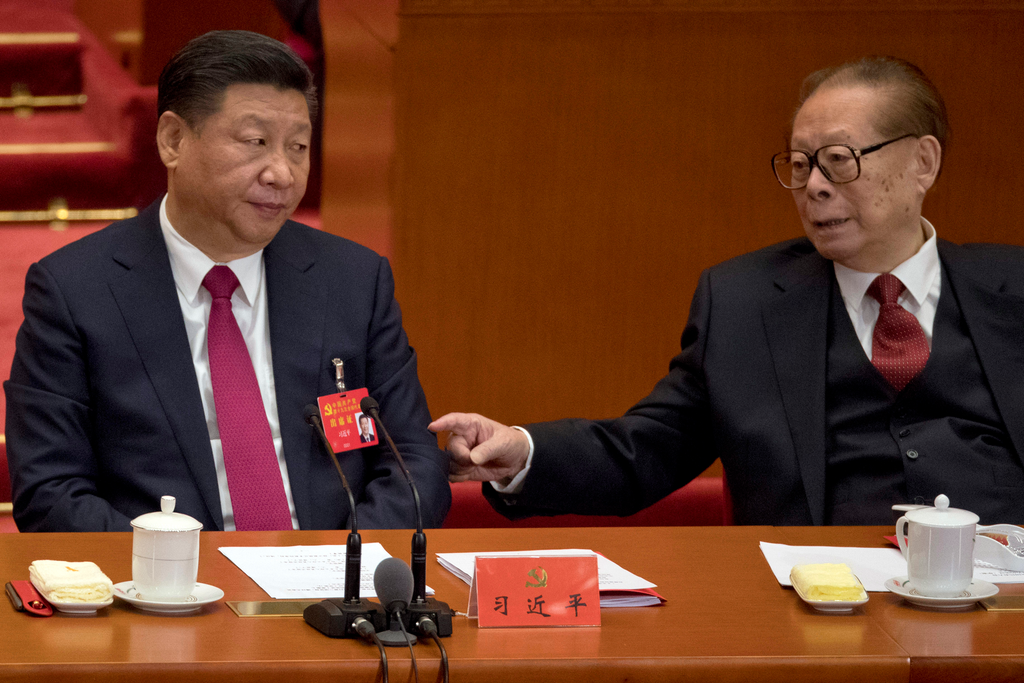 Former Chinese President Jiang Zemin [right] taps the arm of Chinese President Xi Jinping during the closing ceremony for the 19th Party Congress at the Great Hall of the People in Beijing, Oct. 24, 2017. Credit: Associated Press