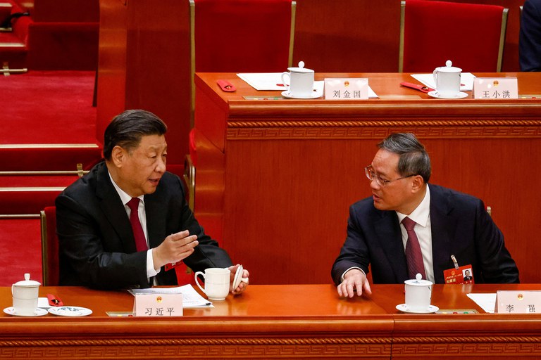Chinese President Xi Jinping talks to Li Qiang, who is expected to become China’s new premier, during the Third Plenary Session of the National People's Congress at the Great Hall of the People, in Beijing, Friday, March 10, 2023. Credit: Pool via Reuters