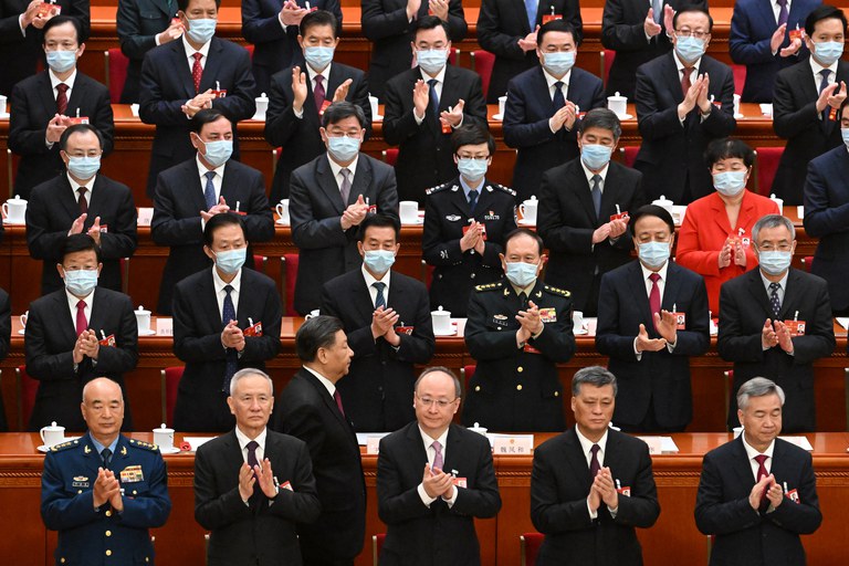 China's President Xi Jinping [bottom, third from left] walks back to his seat after taking the oath of office after being re-elected for a third term, during the third plenary session of the National People's Congress in Beijing on Friday, March 10, 2023. Credit: AFP