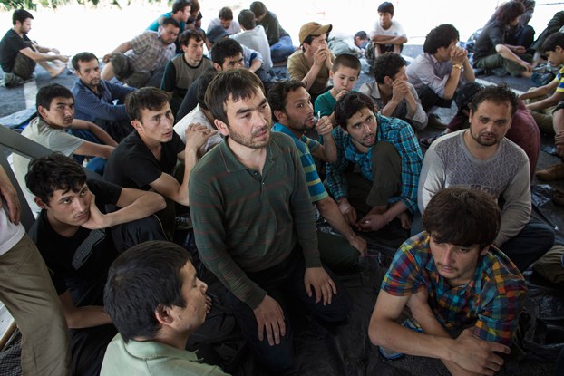 People believed to be Uyghurs sit inside a temporary shelter after they were detained near the Thailand-Malaysia border in Hat Yai, southern Thailand's Songkla province, March 14, 2014. Credit: Reuters