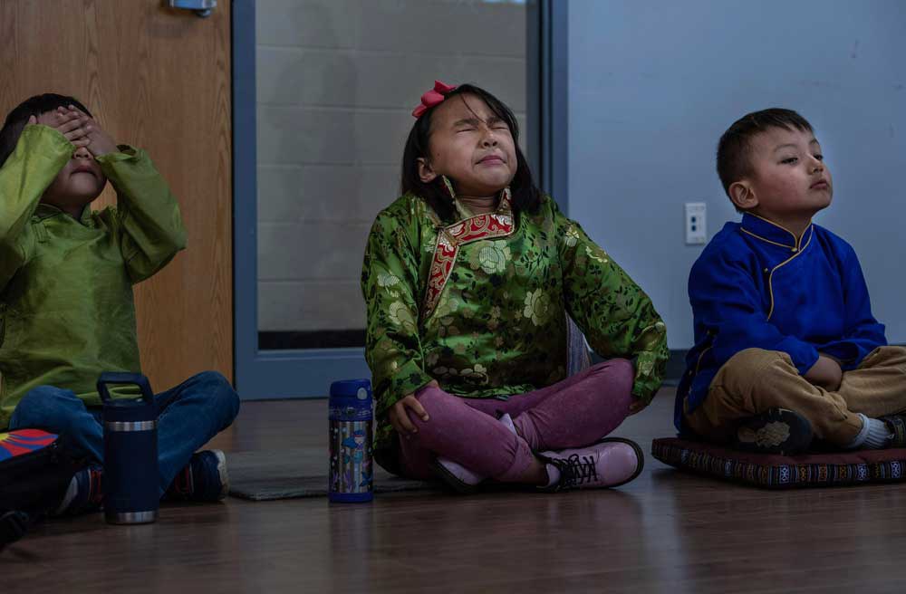 Children dressed in traditional Tibetan clothes try to concentrate as they learn how to meditate at weekly Tibetan language school in Vienna Community Center in northern Virginia, Sunday, May 7, 2023. Credit: Gemunu Amarasinghe/RFA