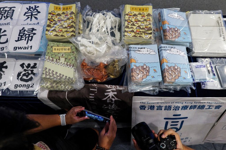 Members of the media take photos of evidence on display, including children's books trying to explain the city's democracy movement, at a police press conference in Hong Kong, after five members of a pro-democracy Hong Kong union were arrested for sedition for publishing the titles, July 22, 2021. Credit: AFP
