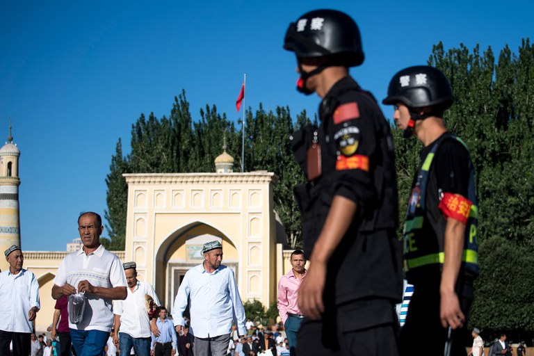 Police patrol as Muslims leave the Id Kah Mosque after the morning prayer on Eid al-Fitr in the old town of Kashgar in China's Xinjiang Uyghur Autonomous Region, June 26, 2017. Ben Dooley/AFP