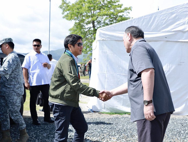 Philippine President Ferdinand Marcos Jr. (left) is greeted by Defense Secretary Gilberto Teodoro Jr. as he arrives to watch drills with Australian and U.S. troops in San Antonio town in Zambales, Philippines, Aug. 25, 2023. Credit: Handout photo/Philippines Department of National Defense
