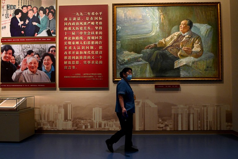 A worker walks in front of a painting of late Chinese leader Deng Xiaoping at the Museum of the Communist Party of China in Beijing, June 25, 2021. Credit: Noel Celis/AFP