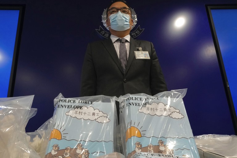 Li Kwai-wah, senior superintendent of Police National Security Department, poses with banned children's books on stories that revolve around a village of sheep which has to deal with wolves from a different village in Hong Kong, July 22, 2021. Authorities in Hong Kong have charged a man with "possession of seditious publications" after he bought copies of the banned "Sheep Village" series of children's picture books from the United Kingdom. Credit: Vincent Yu/AP