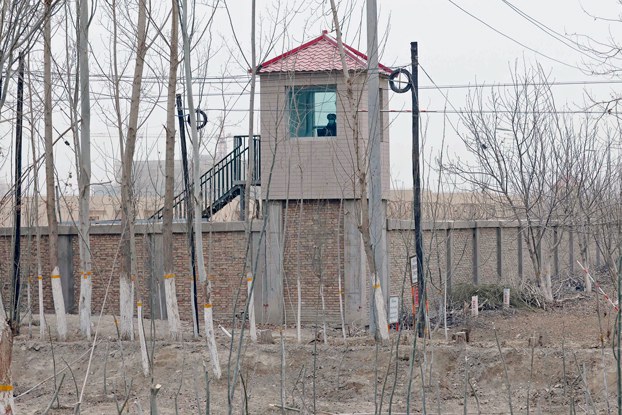 A security guard watches from a tower at a detention facility in Yarkent County in northwestern China's Xinjiang Uyghur Autonomous Region, March 21, 2021. Credit: Ng Han Guan/AP