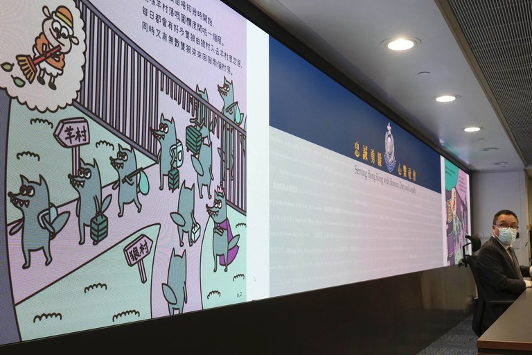 Li Kwai-wah, a senior police officer of Hong Kong speaks in front of a screen showing contents of banned children's books during a press conference in Hong Kong, July 22, 2021. Authorities in Hong Kong have charged Kurt Leung with "possession of seditious publications" after he bought copies of the banned "Sheep Village" series of children's picture books from the United Kingdom. Credit: Vincent Yu/AP