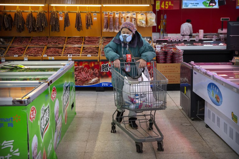 A woman with a face mask pushes her trolley at a grocery store in Beijing, in 2020. China’s post-pandemic economic consumption recovery didn’t happen as expected.Credit: Mark Schiefelbein/AP
