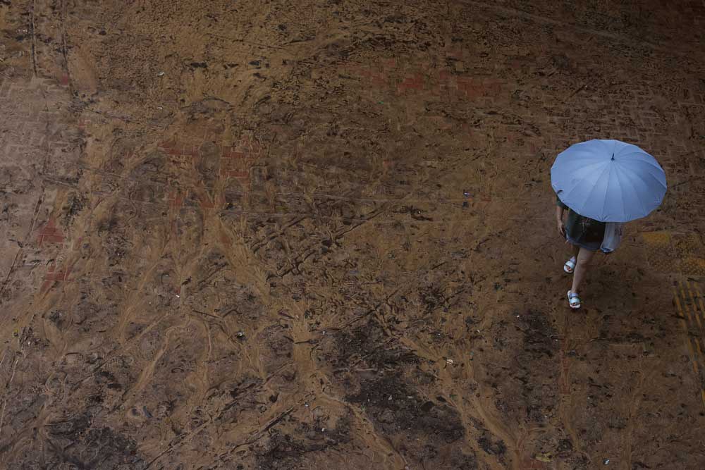 A person walks through mud in the aftermath of flooding and heavy rain in Hong Kong, Friday, Sept. 8, 2023. Credit: Tyrone Siu/Reuters