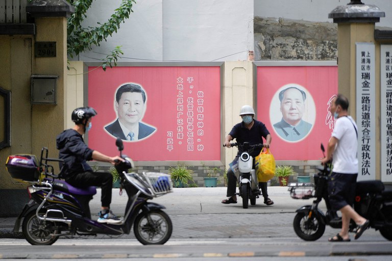 People pass portraits of Chinese President Xi Jinping and late Chinese chairman Mao Zedong In Shanghai, China, Aug. 31, 2022. Credit: Aly Song/Reuters