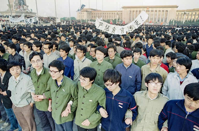Chinese students link arms in solidarity at dawn on April 22, 1989 in Beijing’s Tiananmen Square after spending the night there in order to be on hand for memorial services for the late purged party chief Hu Yaobang. Credit: Sadayuki Mikami/AP