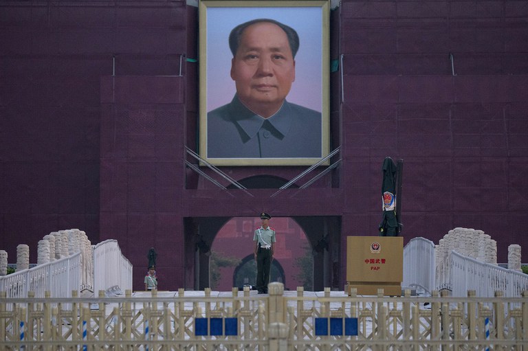 A Chinese paramilitary policeman stands guard in front of Mao Zedong's portrait on Tiananmen Gate, Credit: Ng Han Guan/AP