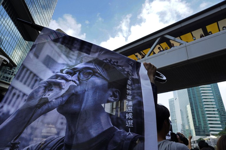 Supporters hold a banner with a picture of Hong Kong activist Edward Leung as they shout slogans outside the High Court in Hong Kong in 2019. Credit: Vincent Yu/AP