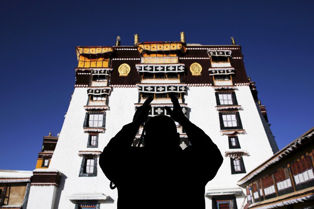 A Tibetan prays at Potala Palace in Lhasa, capital of western's China's Tibet Autonomous Region, Nov. 17, 2015. The Potala Palace, once the seat of Tibetan government and  traditional residence of Dalai Lama, is a 13-story palace with more than 1,000 rooms. (Damir Sagolj/Reuters)
