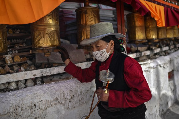 A pilgrim spins a prayer wheel at a Buddhist shrine in Lhasa, capital of western China's Tibet Autonomous Region, during a government-organized media tour on June 3, 2021. (Hector Retamal/AFP)
