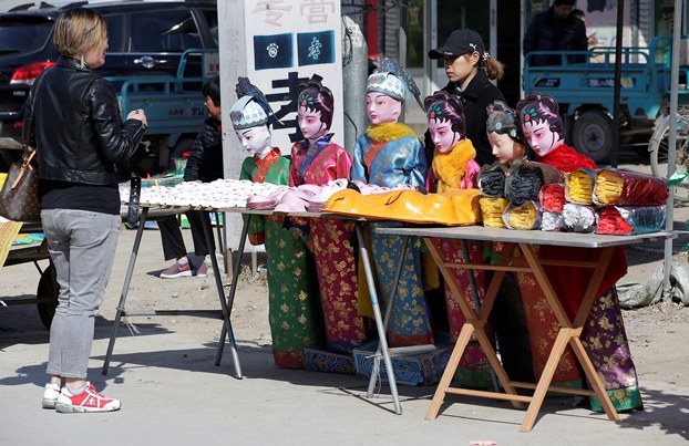 Ein Kunde bespricht die Preise mit einer Verkäuferin neben Angeboten auf einem Großhandelsmarkt, auf dem Vorräte für zeremonielle Riten für Verstorbene verkauft werden, in Mibeizhuang, Kreis Xiong, in der nordchinesischen Provinz Hebei, 24. März 2019, vor dem Qingming-Fest. (Jason Lee/Reuters)