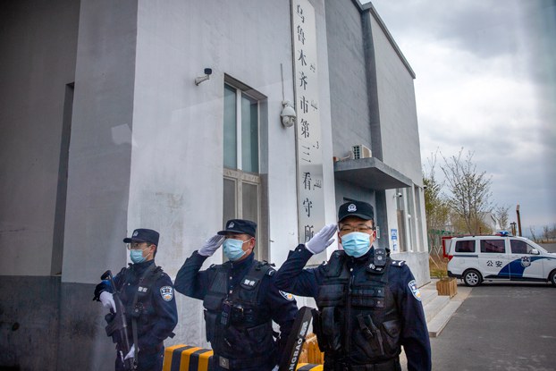 Police officers salute at the outer entrance of the Urumqi No. 3 Detention Center in Dabancheng in northwestern China's Xinjiang Uyghur Autonomous Region, April 23, 2021.
