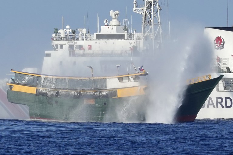 The Philippine resupply vessel Unaizah May 4 (foreground) is hit by two Chinese coast guard water cannons as it tries to enter the Second Thomas Shoal, locally known as Ayungin Shoal, in the disputed South China Sea, March 5, 2024. (Aaron Favila/AP)